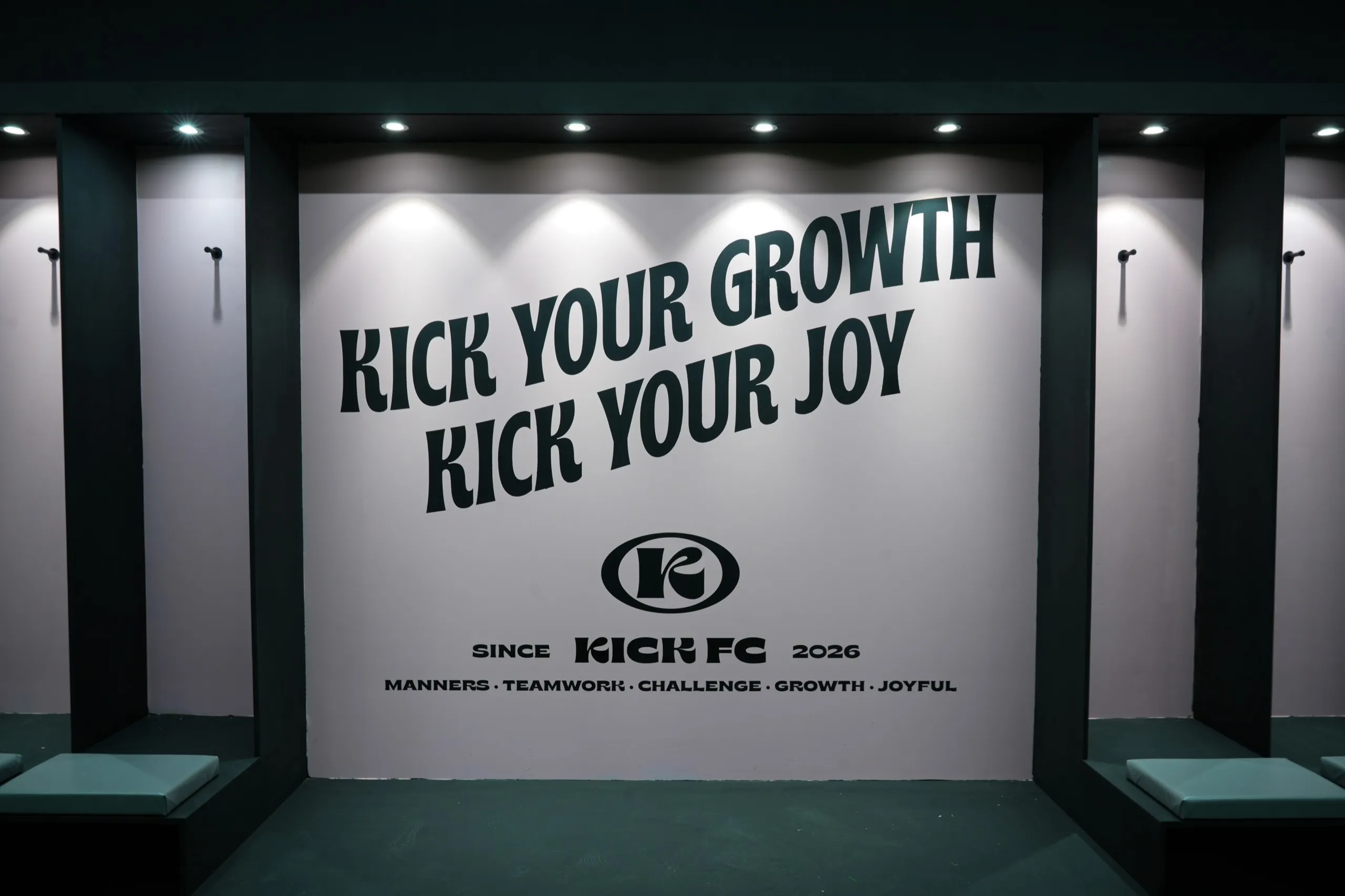 벤치가 놓인 라운지 벽면에 KICK YOUR GROWTH KICK YOUR JOY 문구와 킥에프씨 로고, 다섯 가지 핵심가치가 쓰여 있다.