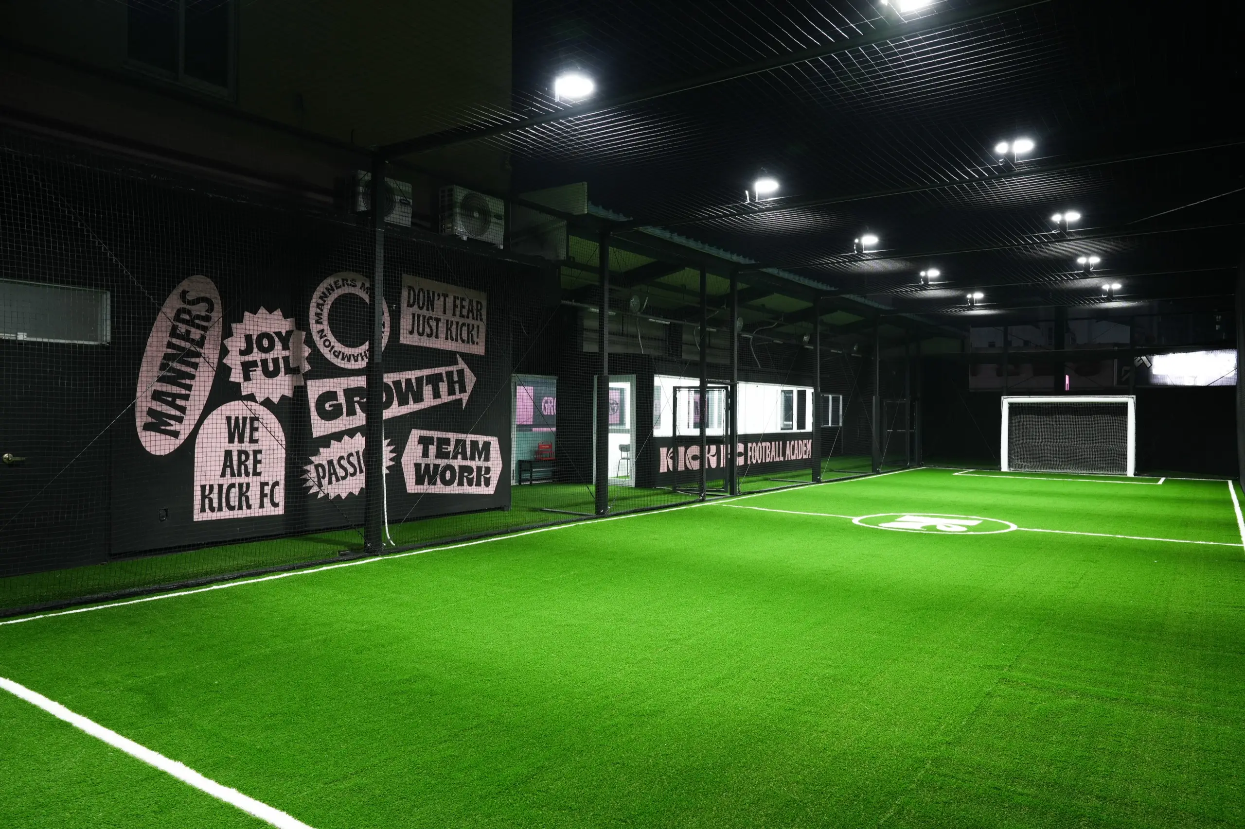 킥에프씨 실내 축구장 전경. 인조잔디 구장과 벽면의 KICK FC 가치 사이니지.